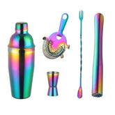 Set cocktail 4 pièces effet arc-en-ciel : shaker, passoire, doseur, cuillère et pilon présentés sur fond blanc.