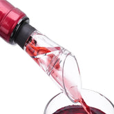 Gros plan sur le bec verseur à vin en action, versant du vin rouge depuis la bouteille dans un verre.