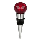 Bouchon de bouteille en forme de bille en cristal rouge facetté sur embout inox, fond blanc