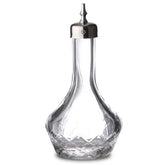 Bouteille à bitter en verre taillé avec bouchon doseur argenté, fermée, sur fond blanc
