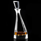 Carafe à whisky moderne en cristal transparent remplie de whisky ambré, photographiée en studio sur fond noir.