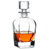 Carafe à whisky en cristal avec bouchon carré, remplie de whisky ambré, sur fond blanc.