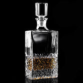 Carafe à whisky en cristal taillé, vide, présentée en packshot sur fond noir.