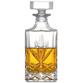 Carafe à whisky sans plomb en cristal taillé, vue de face, remplie de whisky ambré, sur fond blanc.