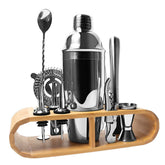 Coffret cocktail cuisine avec shaker inox et accessoires de bar rangés dans leur support en bambou, sur fond blanc