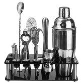Coffret cocktail noir complet avec shaker, doseur, cuillère et accessoires rangés sur son support acrylique, vue de face sur fond blanc.