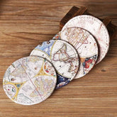 Quatre dessous de verre vintage motif carte du monde disposés en éventail sur un présentoir en bois.