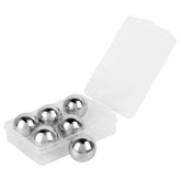 Boîte de six glaçons en inox ouverte sur fond blanc, présentant les billes métalliques polies.