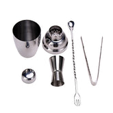 Kit cocktail complet avec shaker trois pièces, verre doseur, cuillère à mélange torsadée et pince à glaçons sur fond blanc