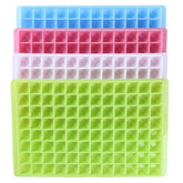Quatre moules à mini glaçons en silicone empilés en bleu, rose, blanc et vert