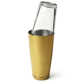 Shaker Boston verre et gobelet doré assemblés, présentés inclinés sur fond blanc