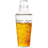 Shaker à cocktail en plastique transparent rempli d'un cocktail ambré, avec les doses et recettes imprimées sur la paroi.