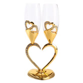 Paire de verres à cocktail avec support en forme de cœur doré serti de strass, sur fond blanc