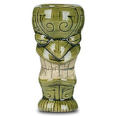 Verre à cocktail tiki vert au visage souriant, photographié de face sur fond blanc.