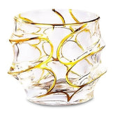 Verre à whisky à dorure vide sur fond blanc, motif en spirales dorées