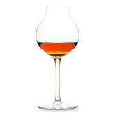 Verre à whisky dégustation rempli d'un whisky ambré, photographié sur fond blanc