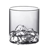Verre à whisky avec relief montagne au fond, vide, sur fond blanc