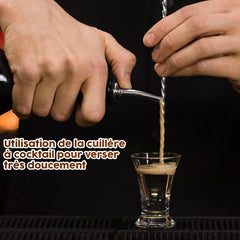 Démonstration de la cuillère à cocktail utilisée pour verser doucement une liqueur en couche dans un petit verre à shot.