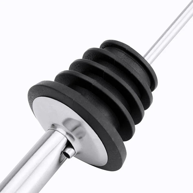 Gros plan sur le bouchon strié en silicone noir et la tige métallique d'un bec verseur.