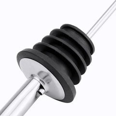 Gros plan sur le bouchon strié en silicone noir et la tige métallique d'un bec verseur.