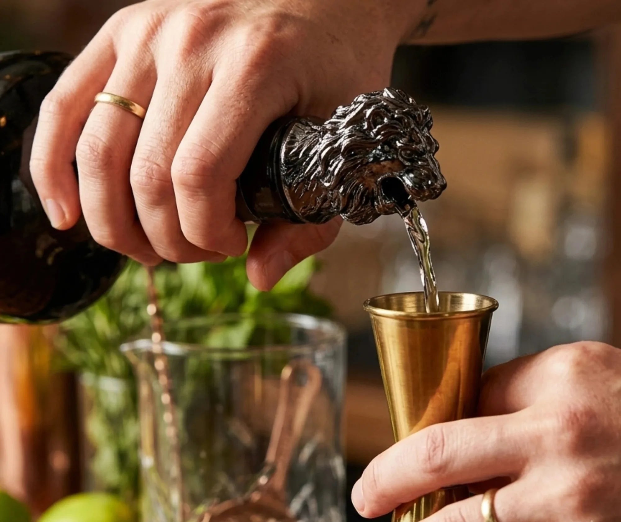 Bec verseur tête de lion utilisé pour verser une liqueur dans un verre doseur en cuivre