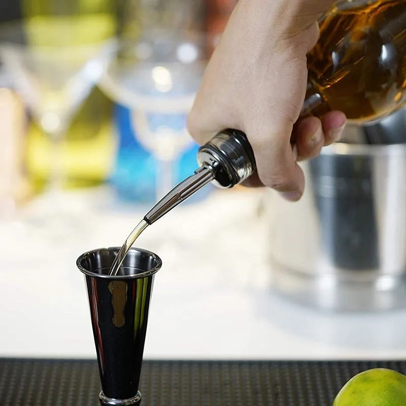 Gros plan sur le verre doseur noir du kit rempli d'alcool versé depuis une bouteille