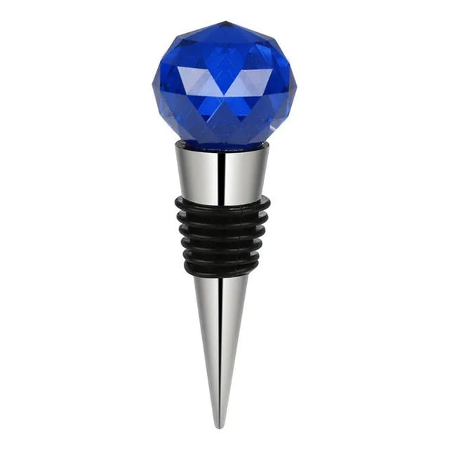 Bouchon de bouteille en forme de bille en cristal bleu facetté sur embout inox, fond blanc