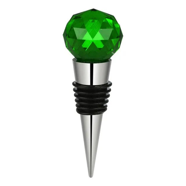 Bouchon de bouteille en forme de bille en cristal vert facetté sur embout inox, fond blanc