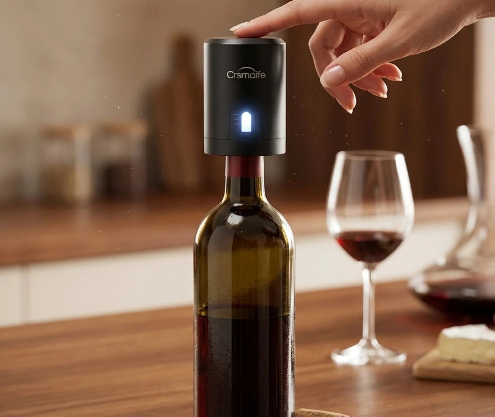 Main appuyant sur le bouton du bouchon pompe à air fixé sur une bouteille de vin ouverte, posée sur une table en bois avec un verre de vin rouge et du fromage en arrière-plan.
