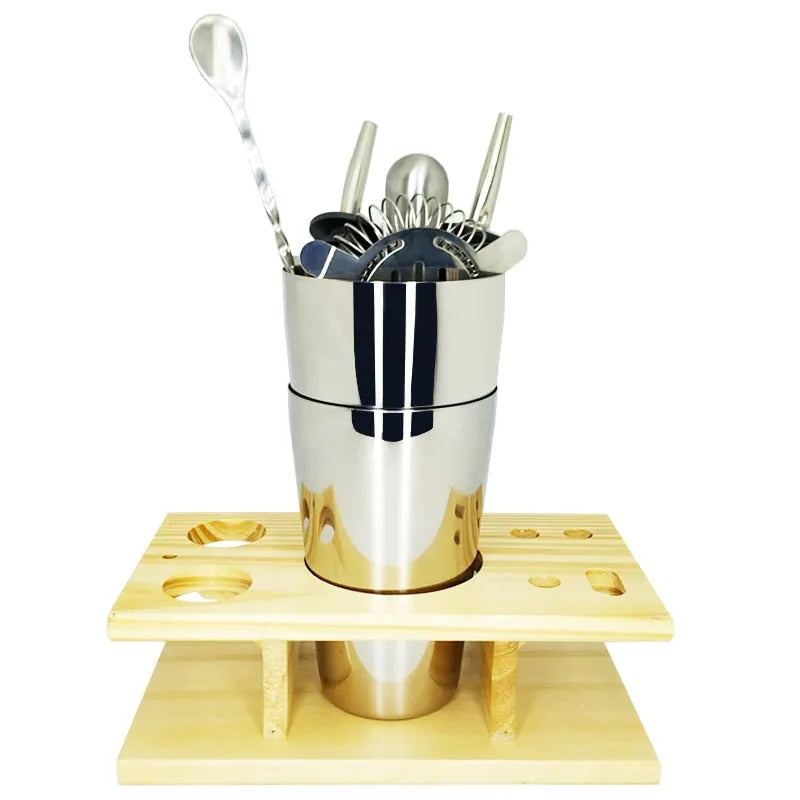 Accessoires du kit cocktail cadeau rangés directement dans le shaker sur le support en bois