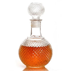 Carafe à whisky ancienne en verre taillé motif diamant, remplie de whisky ambré, sur fond blanc.