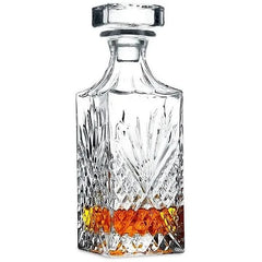 Carafe à whisky en cristal taillé avec bouchon, remplie de whisky ambré, présentée sur fond blanc