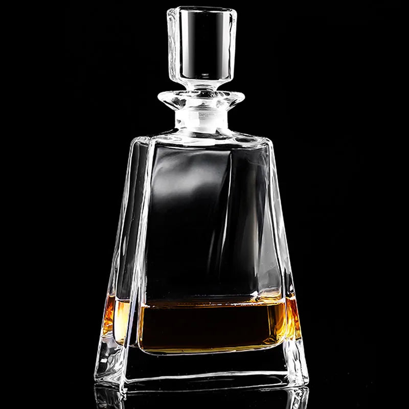 Carafe à whisky en cristal transparent avec bouchon facetté, remplie de whisky ambré, photographiée sur fond noir.