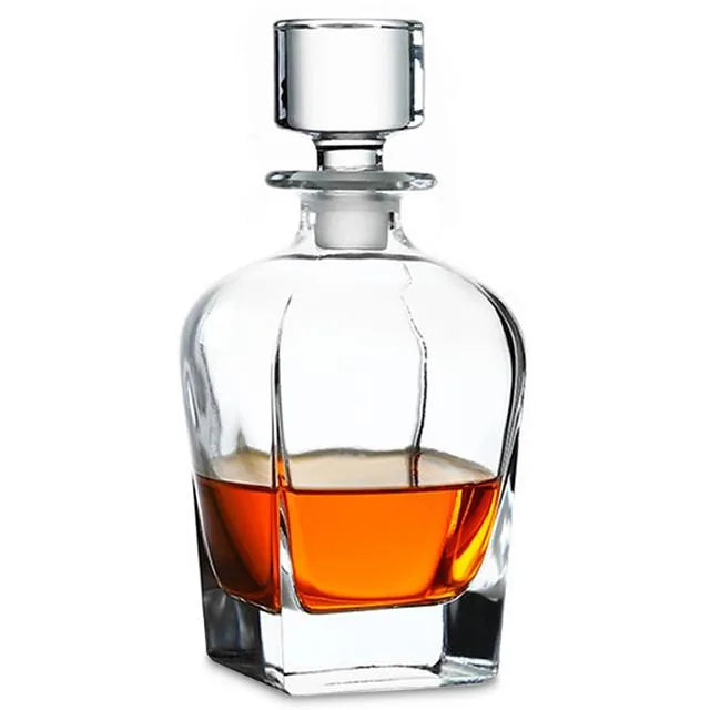 Carafe à whisky en cristal avec bouchon carré, remplie de whisky ambré, sur fond blanc.