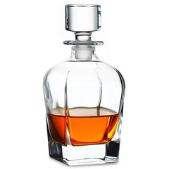 Carafe à whisky en cristal avec bouchon carré, remplie de whisky ambré, sur fond blanc.