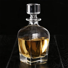 Carafe à whisky en cristal remplie d'alcool ambré, photographiée sur fond noir.