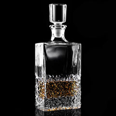 Carafe à whisky en cristal taillé, vide, présentée en packshot sur fond noir.
