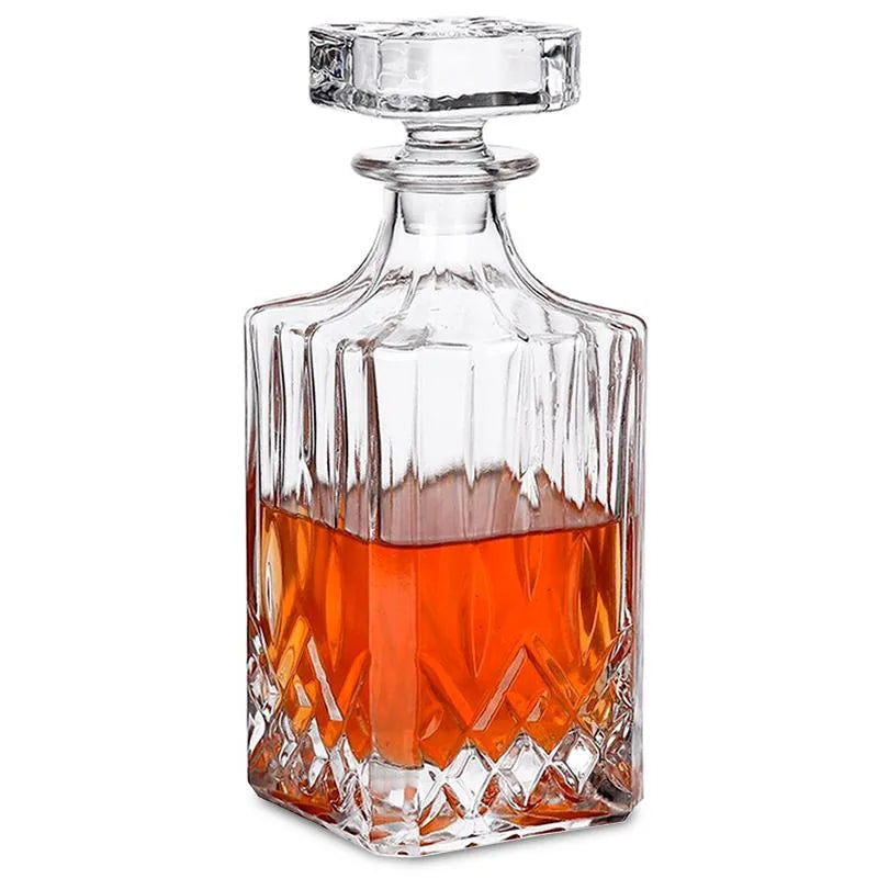 Carafe à whisky en verre taillé avec bouchon facetté, remplie de whisky ambré, photographiée sur fond blanc.