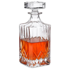 Carafe à whisky en verre taillé avec bouchon facetté, remplie de whisky ambré, photographiée sur fond blanc.