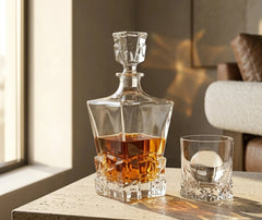 Carafe à whisky irlandais remplie posée sur une console en pierre claire à côté d'un verre assorti, dans un intérieur chaleureux