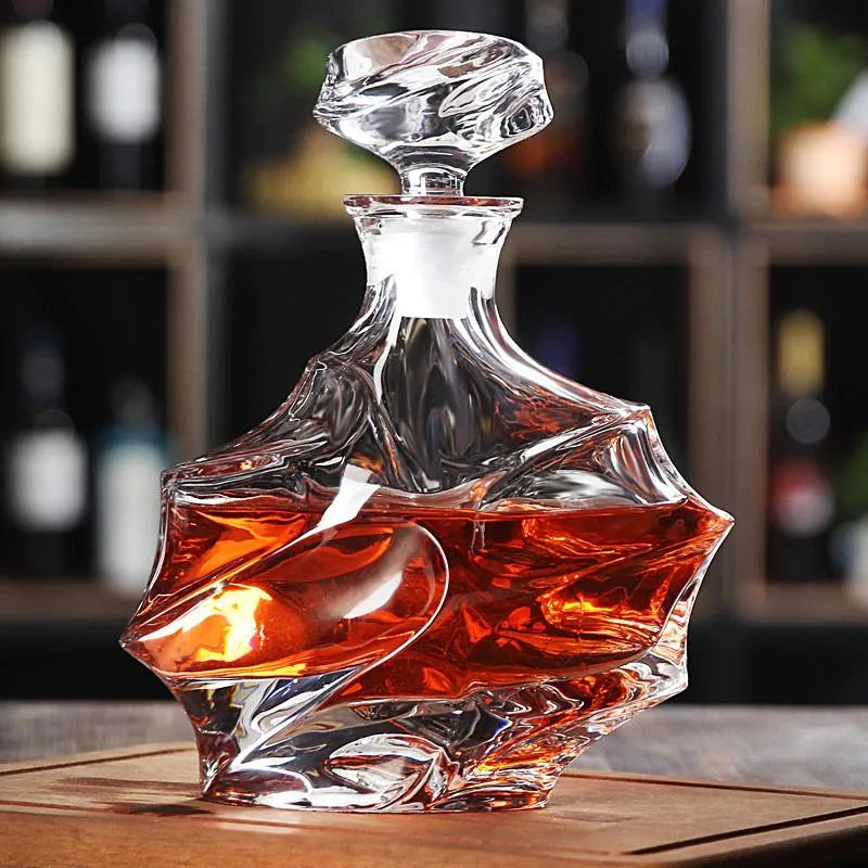 Carafe au design vague posée sur une table en bois, avec une cave à vin garnie de bouteilles floutée à l'arrière-plan.