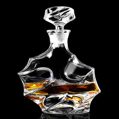 Carafe en cristal au design sculpté en forme de vague, remplie de whisky ambré, photographiée seule sur fond noir.
