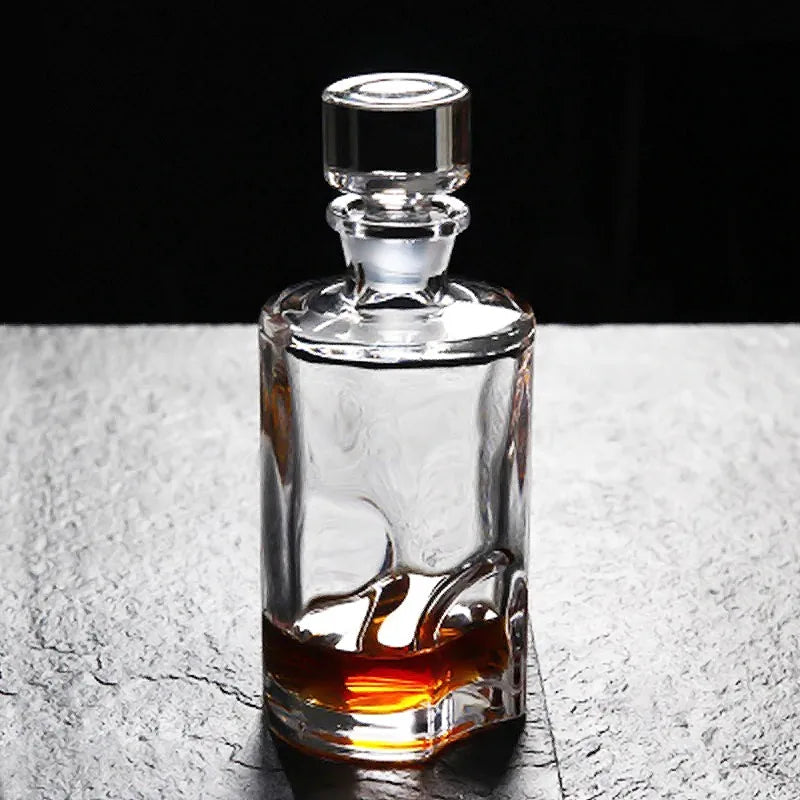 Carafe à whisky ronde en cristal avec bouchon, posée sur une surface en pierre grise, mise en valeur par un éclairage doux.