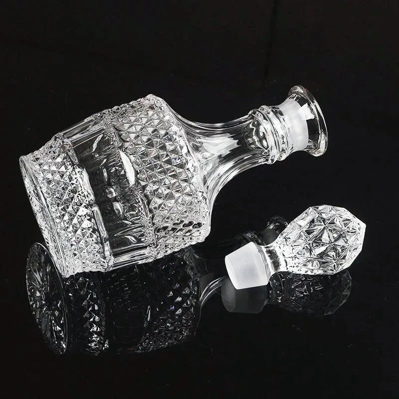 Carafe à whisky vintage vide couchée sur le côté avec son bouchon en cristal détaché, vue détail sur fond noir