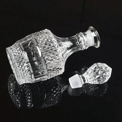Carafe à whisky vintage vide couchée sur le côté avec son bouchon en cristal détaché, vue détail sur fond noir