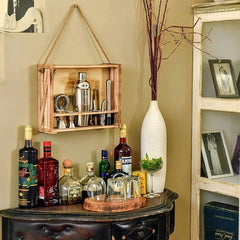Coffret cocktail suspendu au mur comme étagère décorative au-dessus d'un meuble bar dans un salon vintage.