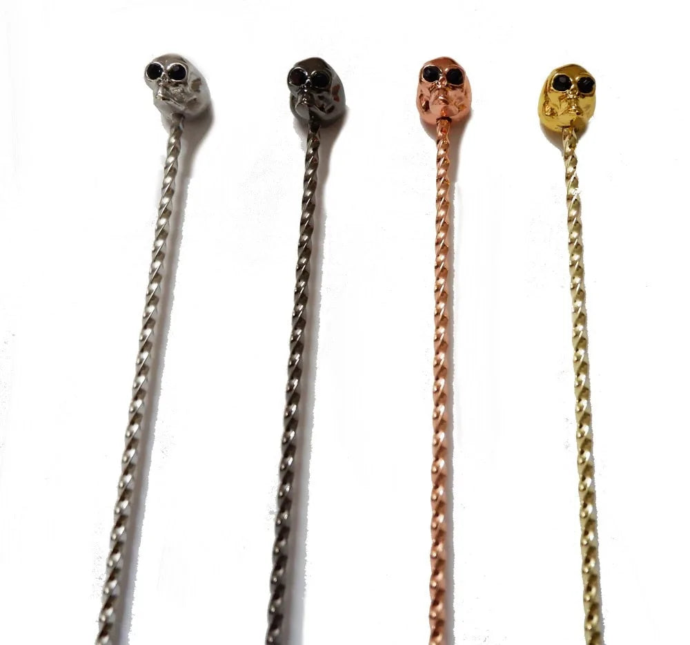 Les quatre coloris disponibles de la cuillère à cocktail tête de mort : argent, bronze, or rose et or.