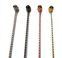 Les quatre coloris disponibles de la cuillère à cocktail tête de mort : argent, bronze, or rose et or.