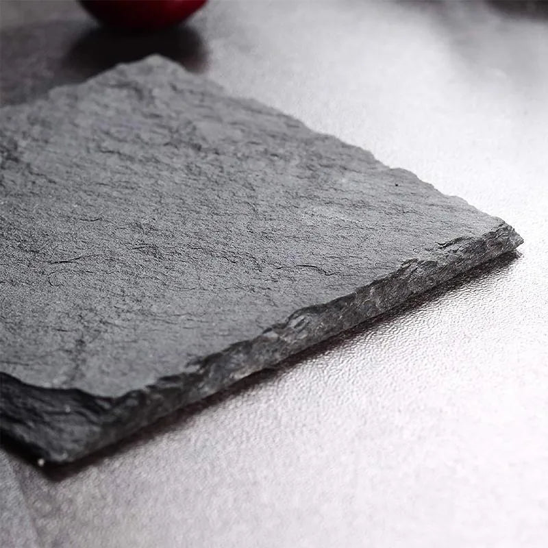 Gros plan sur la texture naturelle et le bord brut d'un dessous de verre en ardoise