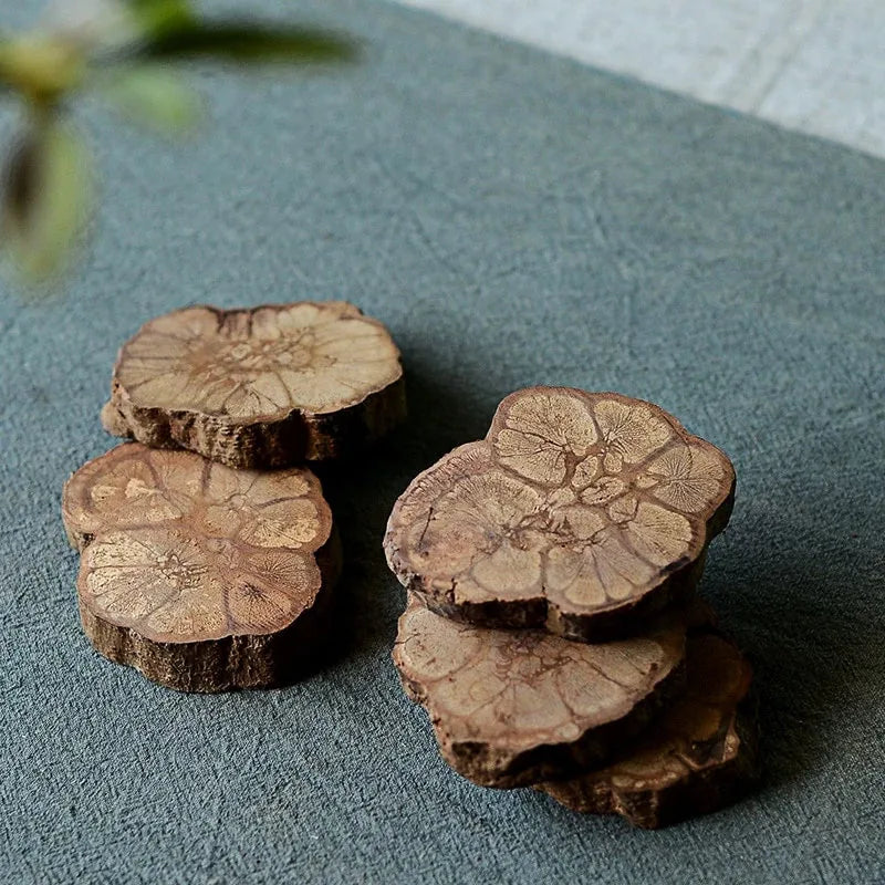 Lot complet de dessous de verre en bûche empilés par groupes, montrant la variété des motifs de bois.